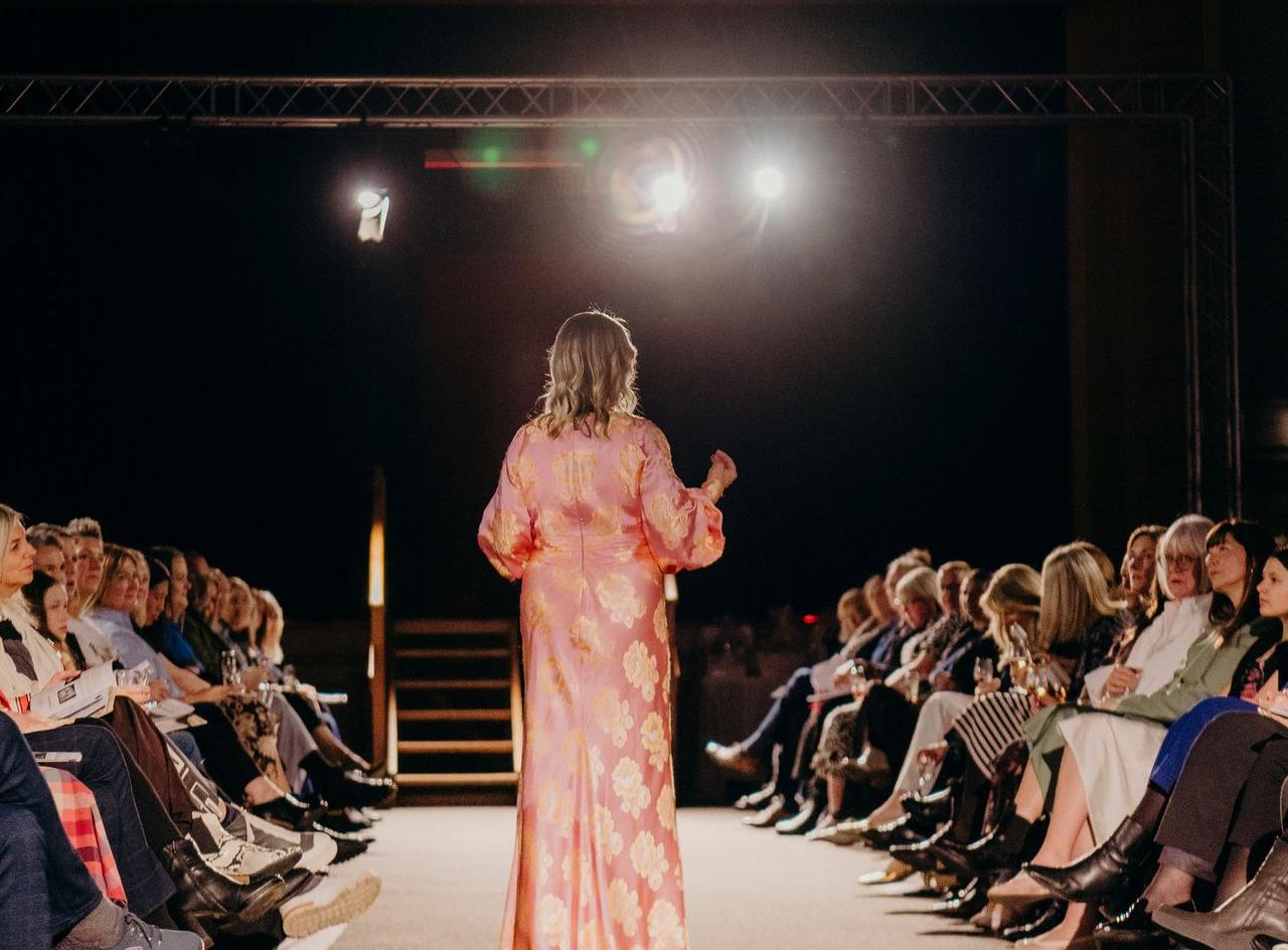 Models and audience at the Fashion at McGlashan runway, lit end-to-end by Cue-Go